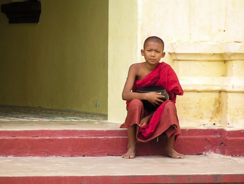 Giovane monaco buddista su scalini tempio Bagan Myanmar