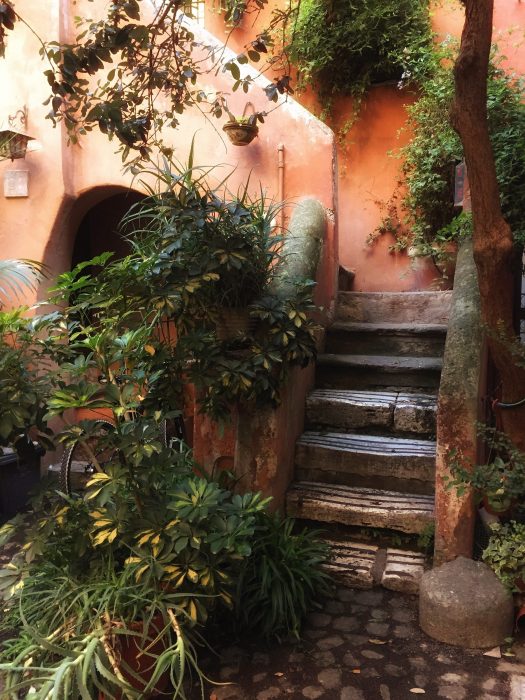 Cortile medievale Arco degli Acetari Roma case color terracotta rampicanti