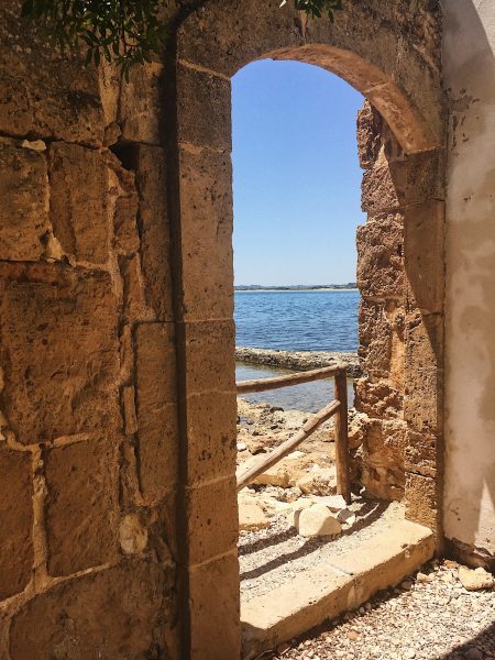 Paesaggio naturale nella "Riserva di Vendicari in Sicilia – dune sabbiose, vegetazione mediterranea e cielo limpido, perfetto per turismo sostenibile e rigenerante"