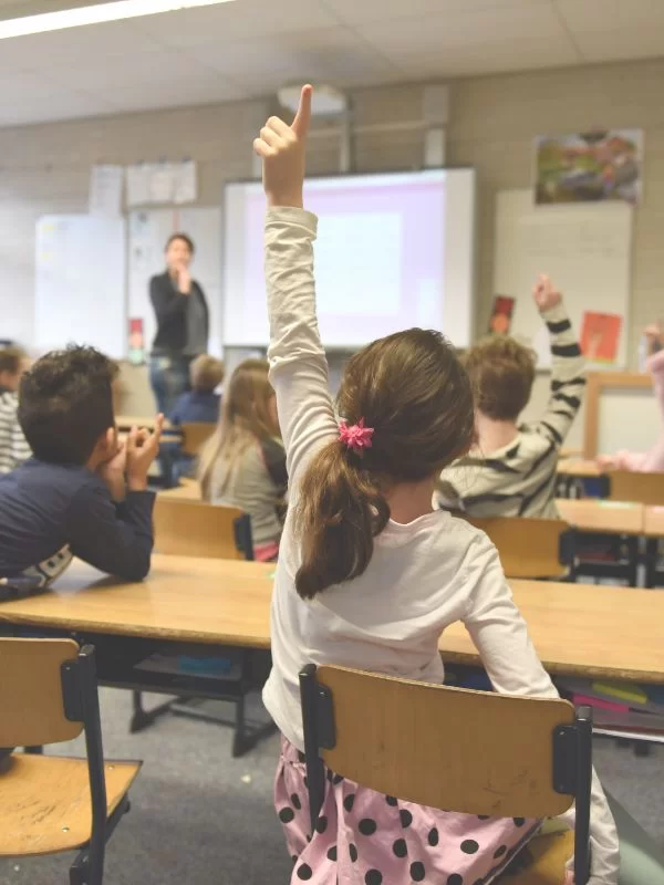 bambini a scuola che alzano la mano effetto pigmalione